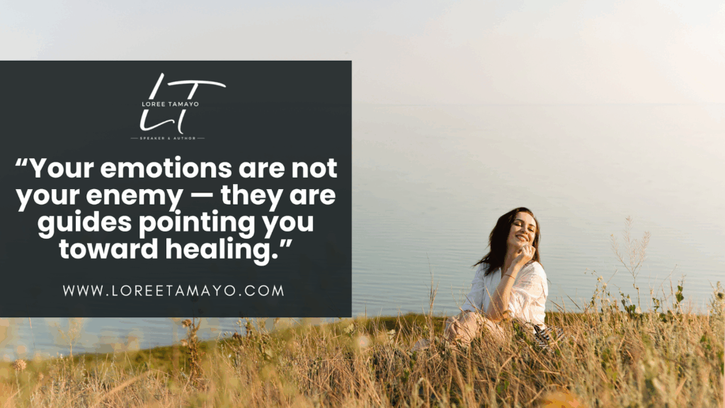 Blog banner featuring a woman sitting peacefully in tall grass near the water, smiling with eyes closed under a clear sky. The text reads: 'Your emotions are not your enemy — they are guides pointing you toward healing.' Loree Tamayo’s logo and website are displayed. The image represents processing emotions as a step toward healing and growth.