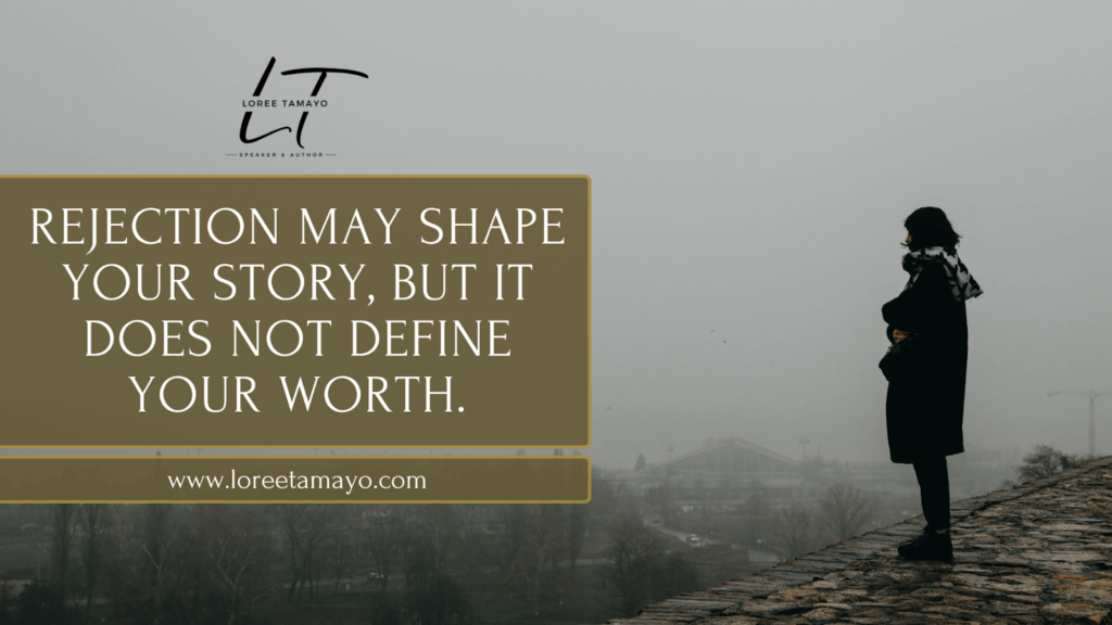 Blog banner with the quote 'Rejection may shape your story, but it does not define your worth' alongside a silhouette of a woman standing on a stone path overlooking a foggy city. Created for Loree Tamayo, speaker and author, with the website www.loreetomayo.com Focused on the effects of rejection and personal worth.