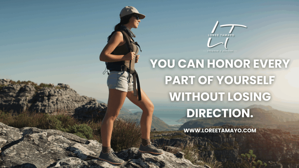 A woman wearing hiking gear stands confidently on a rocky mountain overlook, gazing toward the horizon with a sense of purpose and direction. The Loree Tamayo logo appears on the right above the text: ‘You can honor every part of yourself without losing direction.’ The website www.loreetomayo.com is displayed below.