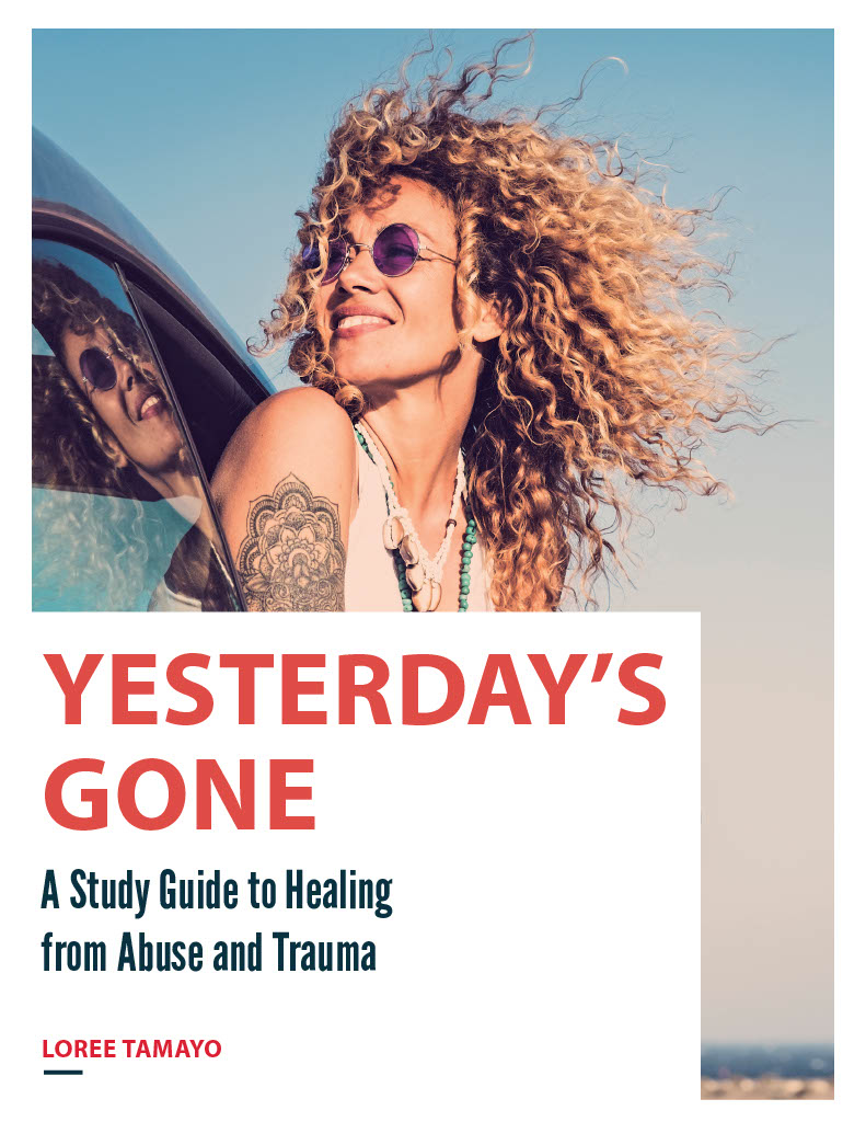 A young woman smiling as she sticks her head out of a car window